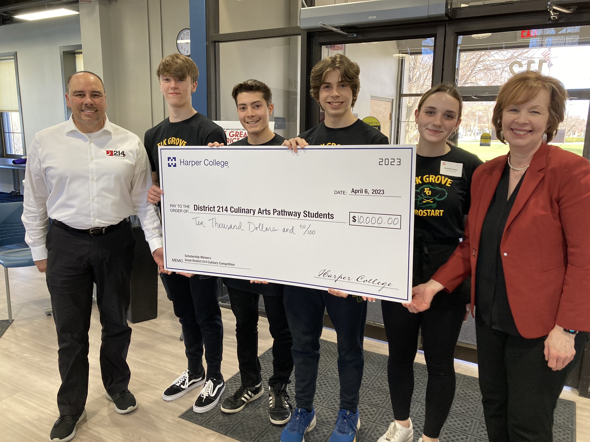 The four winning students hold a large check for $10,000 from Harper College. Next to the students are a representative from District 214 and Senator Gillespie.